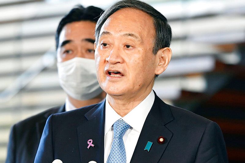 武漢肺炎疫情二波爆發,重創菅義偉民調支持度。(美聯社)
