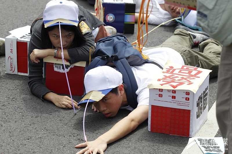 2012年五一勞動節「勞工運動會」,抗議民眾演出行動劇諷刺勞工過勞。(資料照,林旻萱攝)