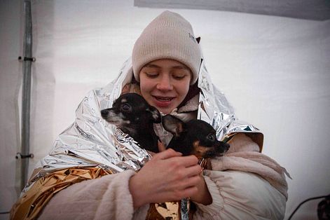 烏克蘭戰爭：女孩 Katya 逃往波蘭邊境後抱著她的狗狗。（美聯社）