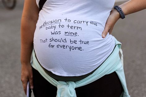 美國聯邦最高法院撤銷墮胎的憲法權利，一名抗議者在孕肚寫：「我懷滿週數的決定是我的。對每個人都該是這樣。」（美聯社）