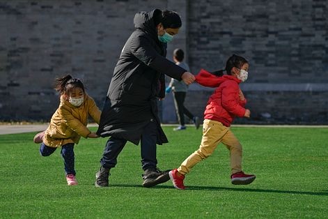 2022年12月4日，北京市民與小孩在綠地上玩耍。（AP）