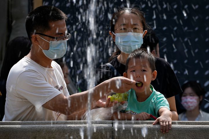 2022年9月18日，北京的公園裡，家長正在餵小孩（AP）