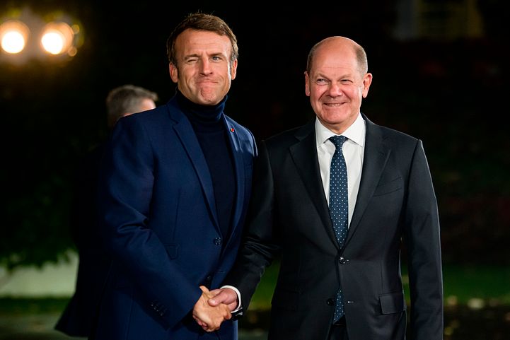 法國總統馬克宏穿著高領上衣現身，右為德國總理蕭爾茨（Olaf Scholz）。（AP）