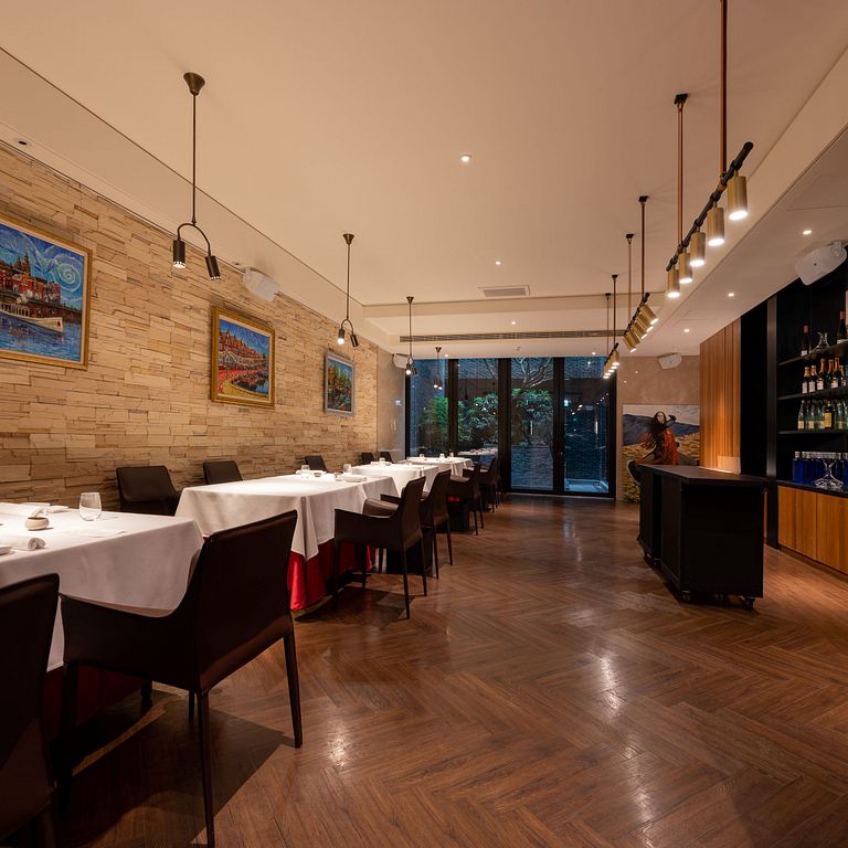 渥達尼斯磨坊空間設計一區延續西班牙本店百年磨坊的石牆風格,大片落地窗與室外百年連結。(圖片來源/慕舍酒店 提供)